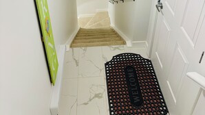 Eine Treppe mit beigem Teppich, die zu einer Zwischenebene führt.