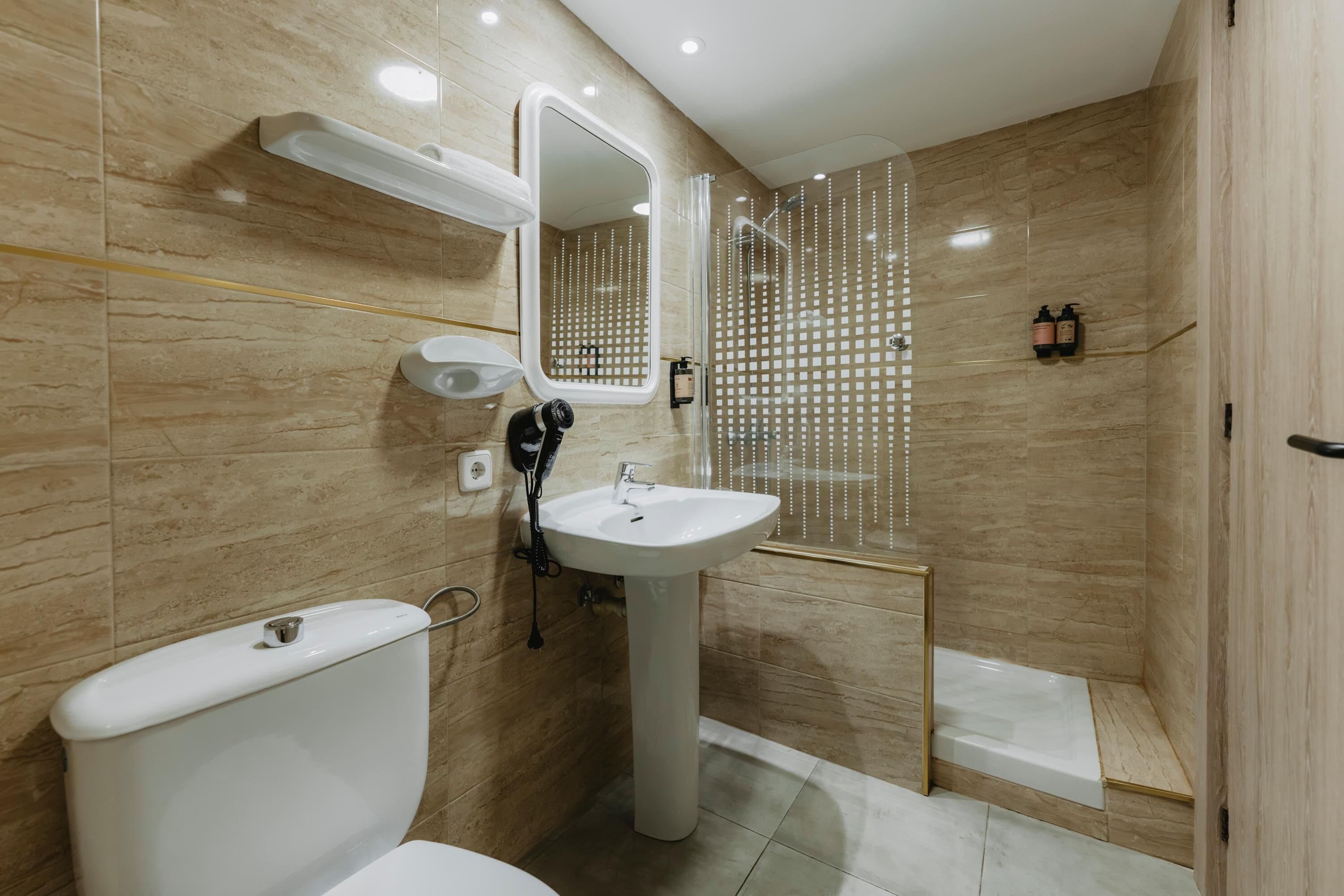 A modern bathroom with a toilet, sink, and shower.