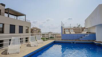 Een seizoensgebonden buitenzwembad, parasols voor strand/zwembad