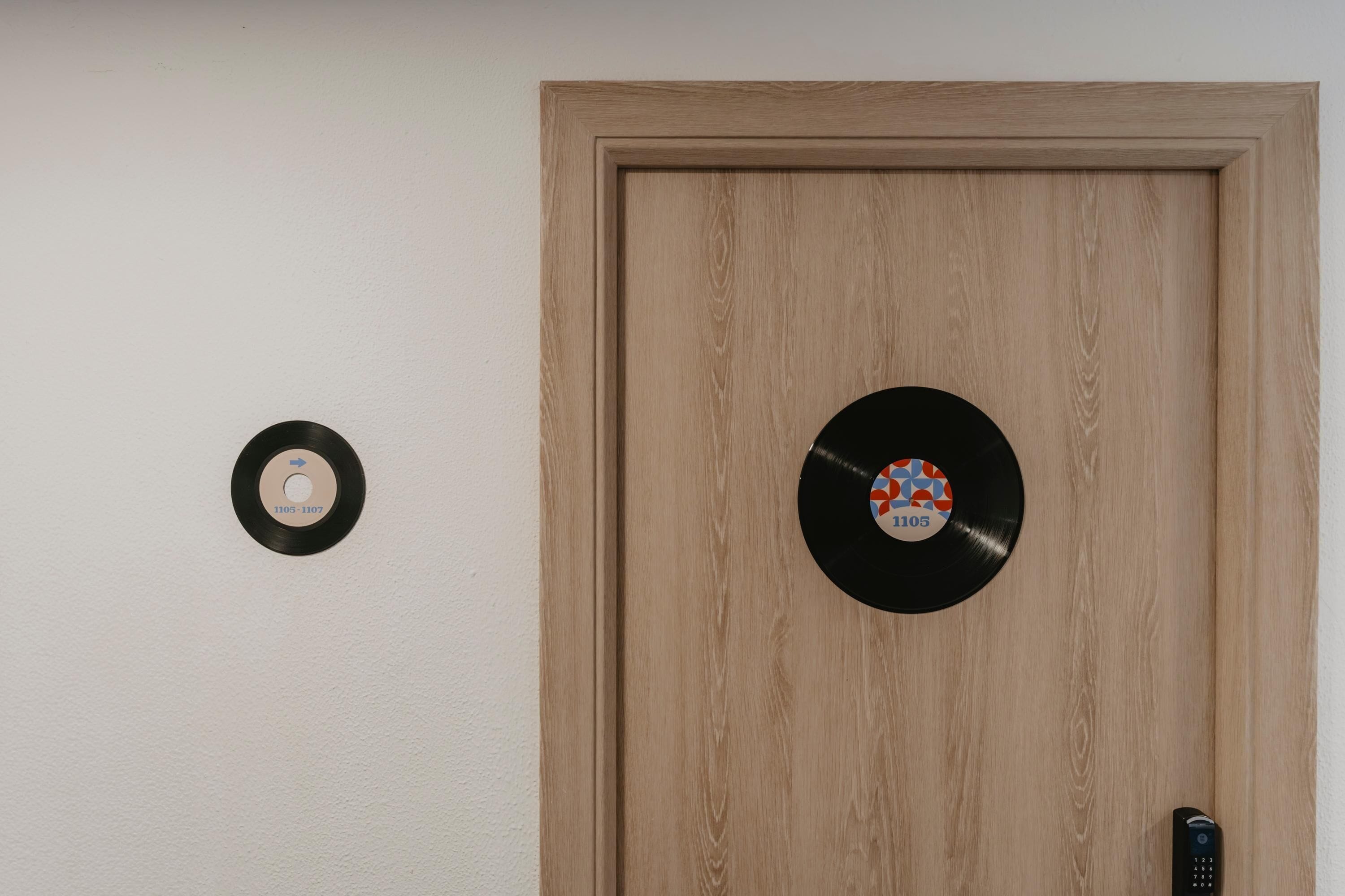 A wooden door with two vinyl records mounted on the wall.
