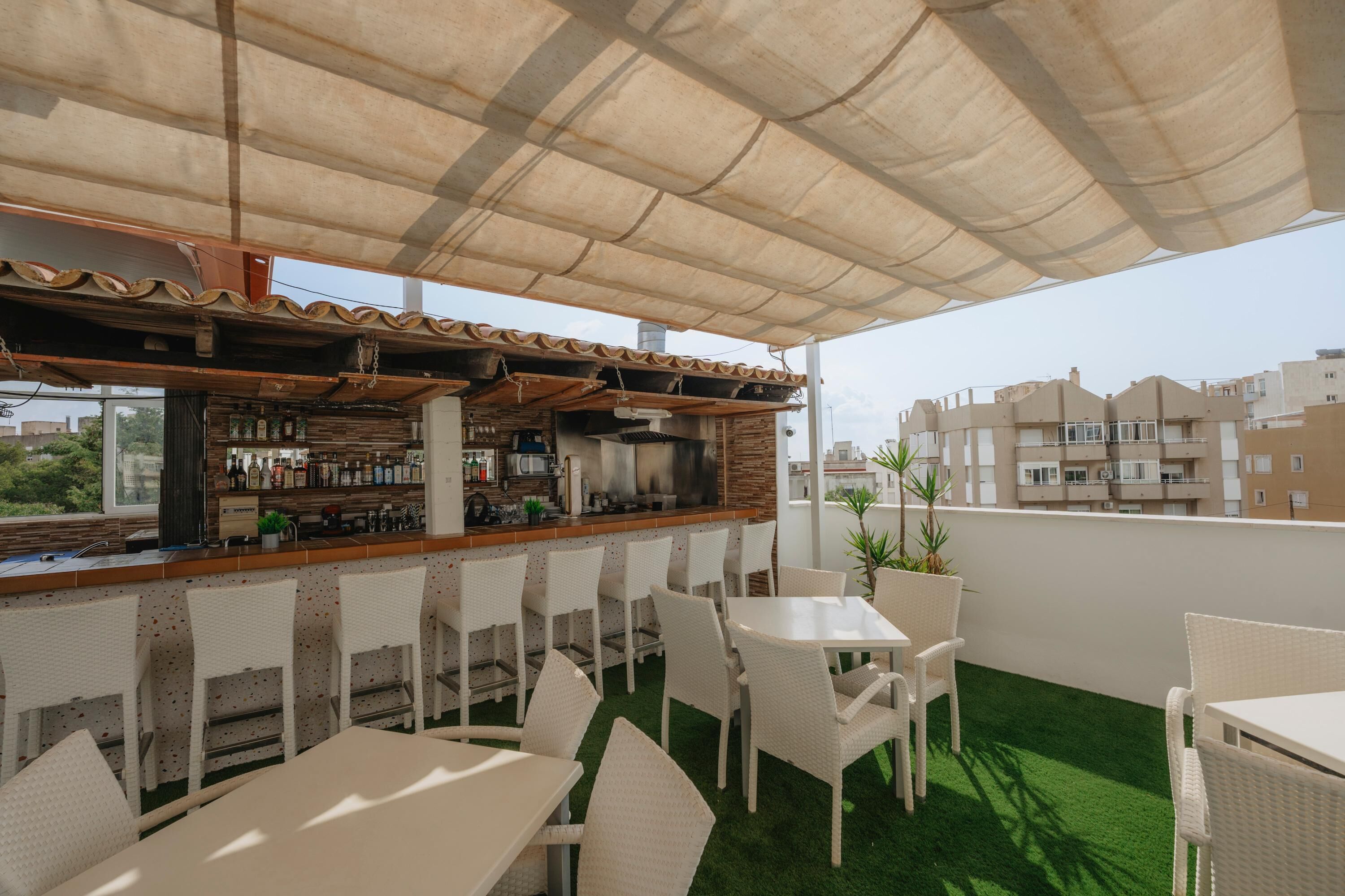 Un'area bar all'aperto con un bancone, sedie e tavoli.