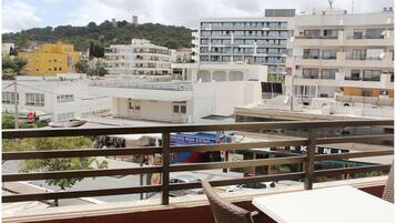 Vista desde un balcón sobre un paisaje urbano con varios edificios, incluyendo un hotel de varios pisos y un estacionamiento.
