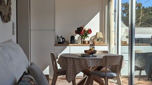 A modern living room with a sofa, a dining table with chairs, a ceiling fan, and a view through large windows. - On the water: XXL Terrace, Paddle, Bikes & A/C. New 2025 + 2 Secure Garages (Cogolin)