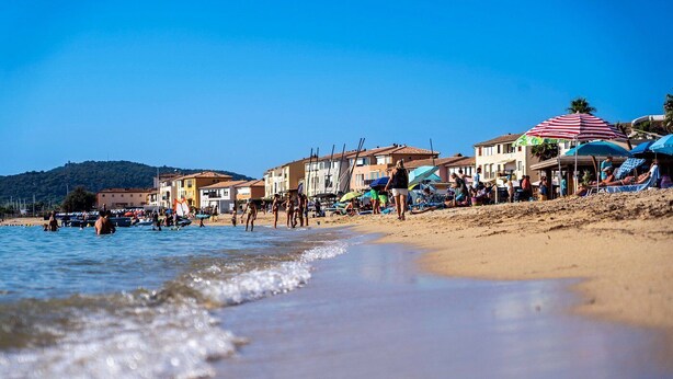 A beach with buildings in the background, a sandy shore, and people enjoying the water. - On the water: XXL Terrace, Paddle, Bikes & A/C. New 2025 + 2 Secure Garages (Cogolin)