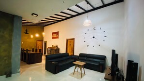 A modern living room with a sectional sofa, a small wooden table, and a wall clock. - 2-bedroom house in nice Pilimathalwa with WiFi, AC (Pilimathalwa)