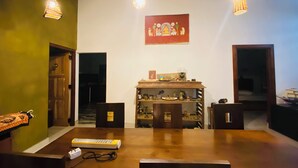 A dining area with a wooden table, chairs, and hanging pendant lights. There is a shelf with various items and a painting on the wall. - 2-bedroom house in nice Pilimathalwa with WiFi, AC (Pilimathalwa)