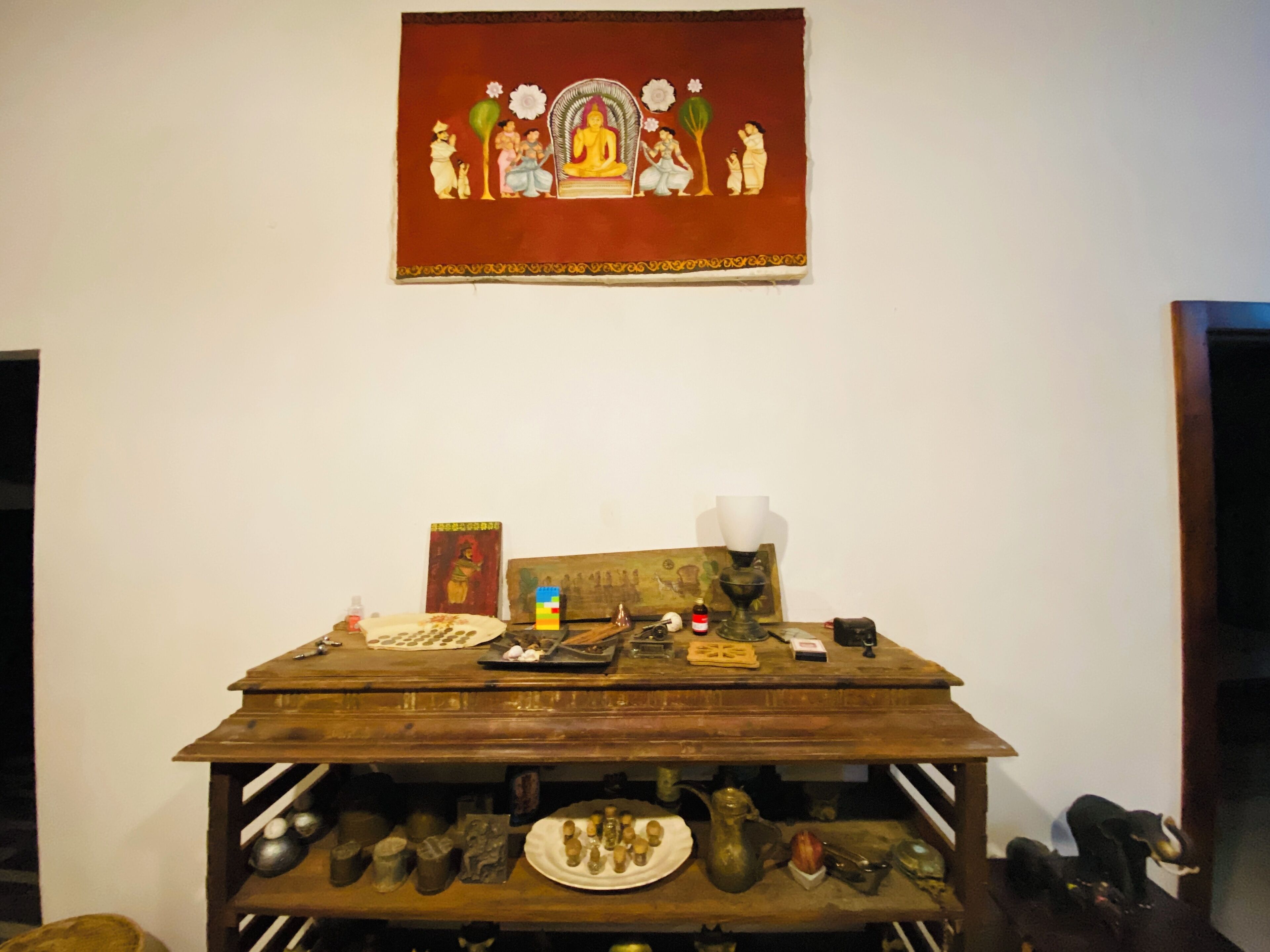 A wooden table with various items including a book, a vase, and a small statue.