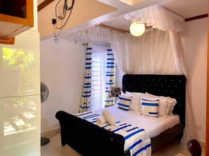 A bedroom with a bed, curtains, and a ceiling fan. - Kogelo Retreat Villas and Homes Kisumu (Kisumu)