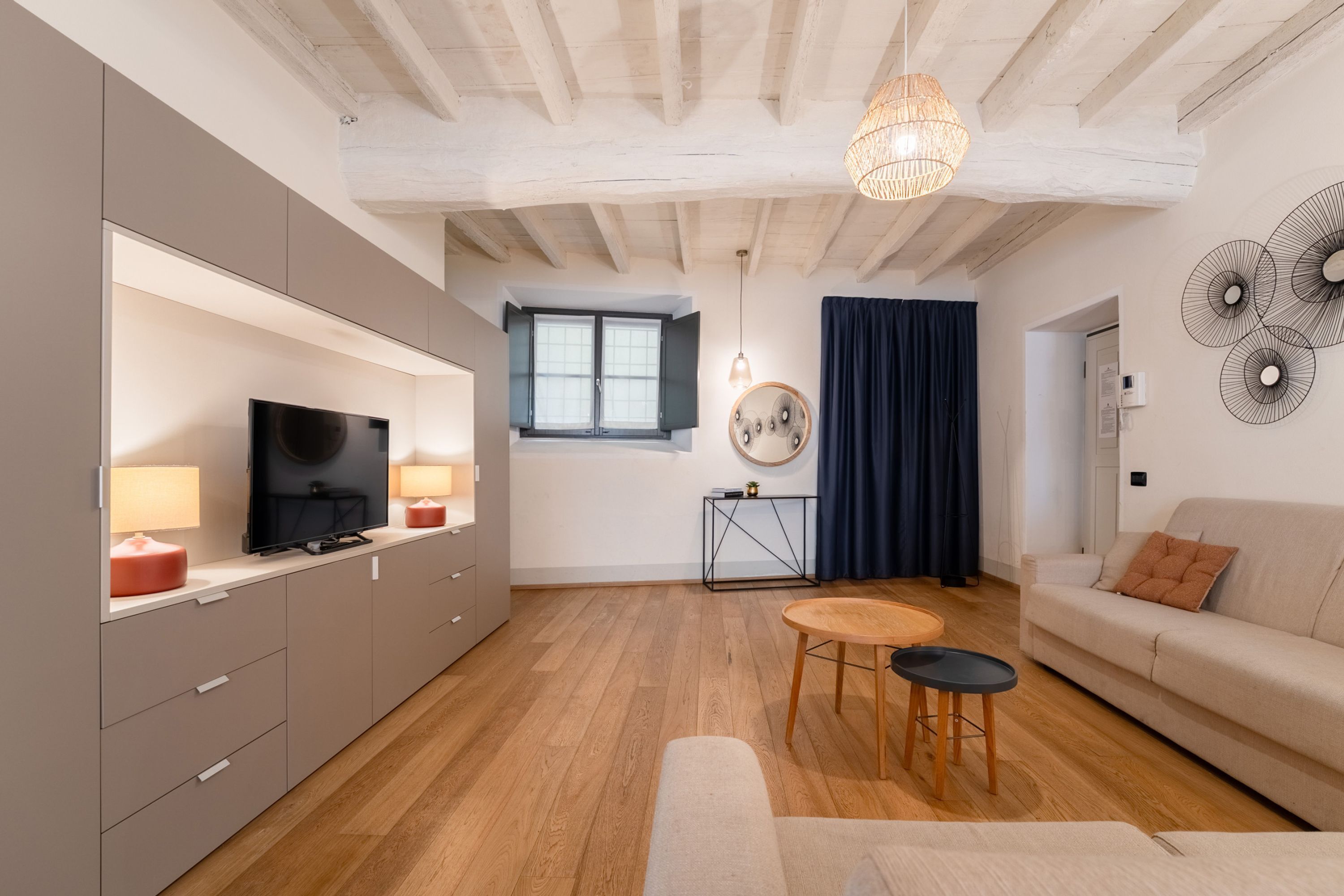 Een moderne woonkamer met een televisie, bank en een eethoek.