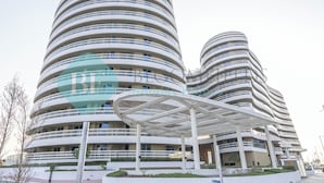A modern, multi-story hotel with a distinctive curved architecture and a covered outdoor area. - Bloomfields 2BR Soul Beach in Saadiyat (Abu Dhabi)