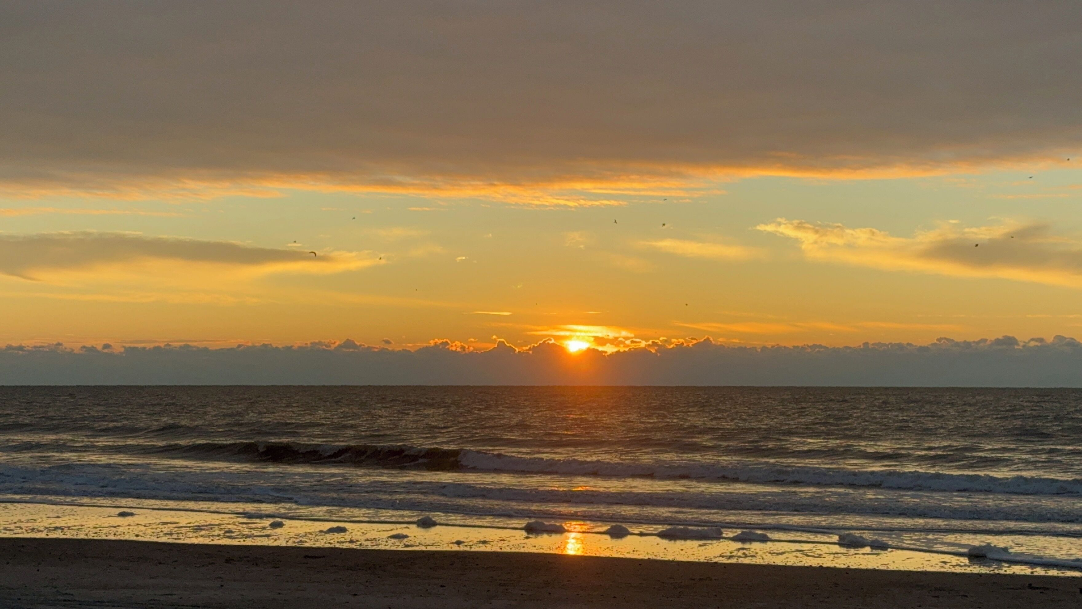 Una spiaggia con onde al tramonto.