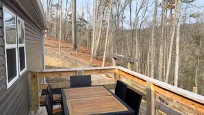 A deck with a table and chairs, overlooking a forested area. - Mountain Top Retreat with ATV Route Access (LaFollette)
