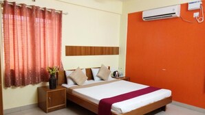 Een slaapkamer met een bed, nachtkastje en een airconditioning.