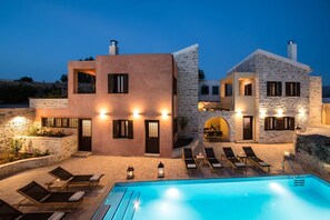 A modern villa with a swimming pool, stone walls, and outdoor seating. - Phaistos Villas - Villa Dafne Poolside Gem (Faistos)