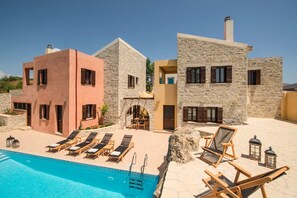 A modern villa with a pool, stone walls, and outdoor seating. - Phaistos Villas - Villa Kastalia Poolside Retreat (Faistos)
