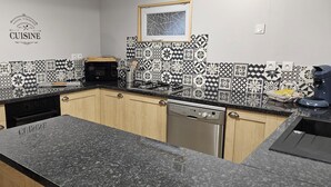 Una cocina con salpicadero de diseño, armarios de madera, microondas, estufa y lavavajillas.