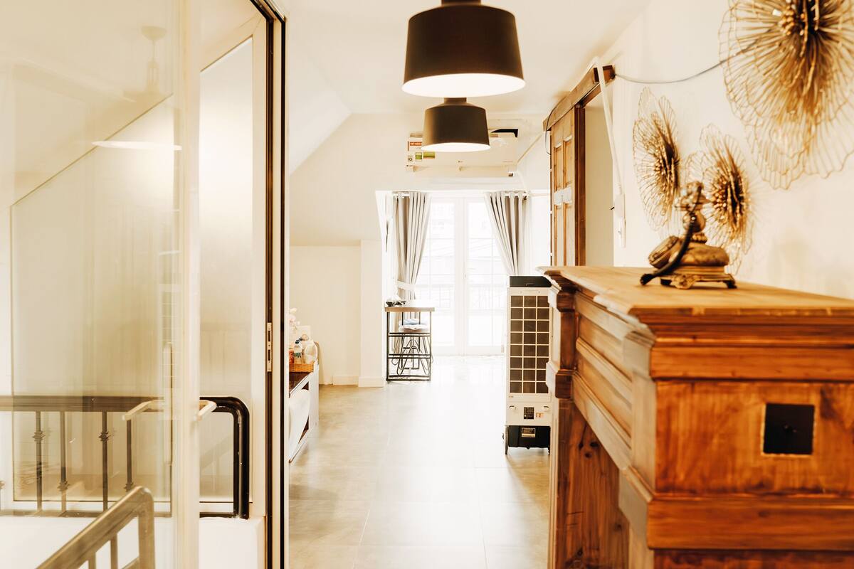 A hallway with a wooden dresser, a radiator, and a ceiling light.