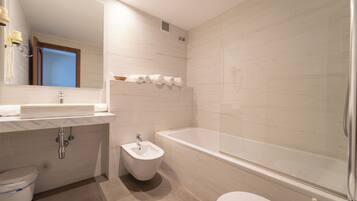 Ein modernes Badezimmer mit Waschbecken, Bidet und Badewanne.