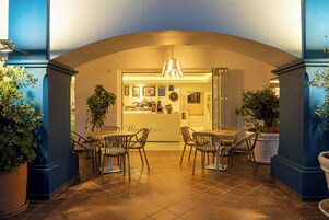 Un restaurant doté d’un bar, d’une terrasse et de plantes en pot.