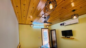 A bedroom with a bed, ceiling fan, TV, and wooden ceiling. - Royal Guest House (Kala Amb)