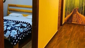 A room with a bed, wooden ceiling, and a staircase with a green wall. - Royal Guest House (Kala Amb)