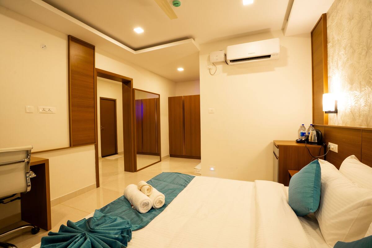 A hotel room with a bed, a bathroom, and a desk.