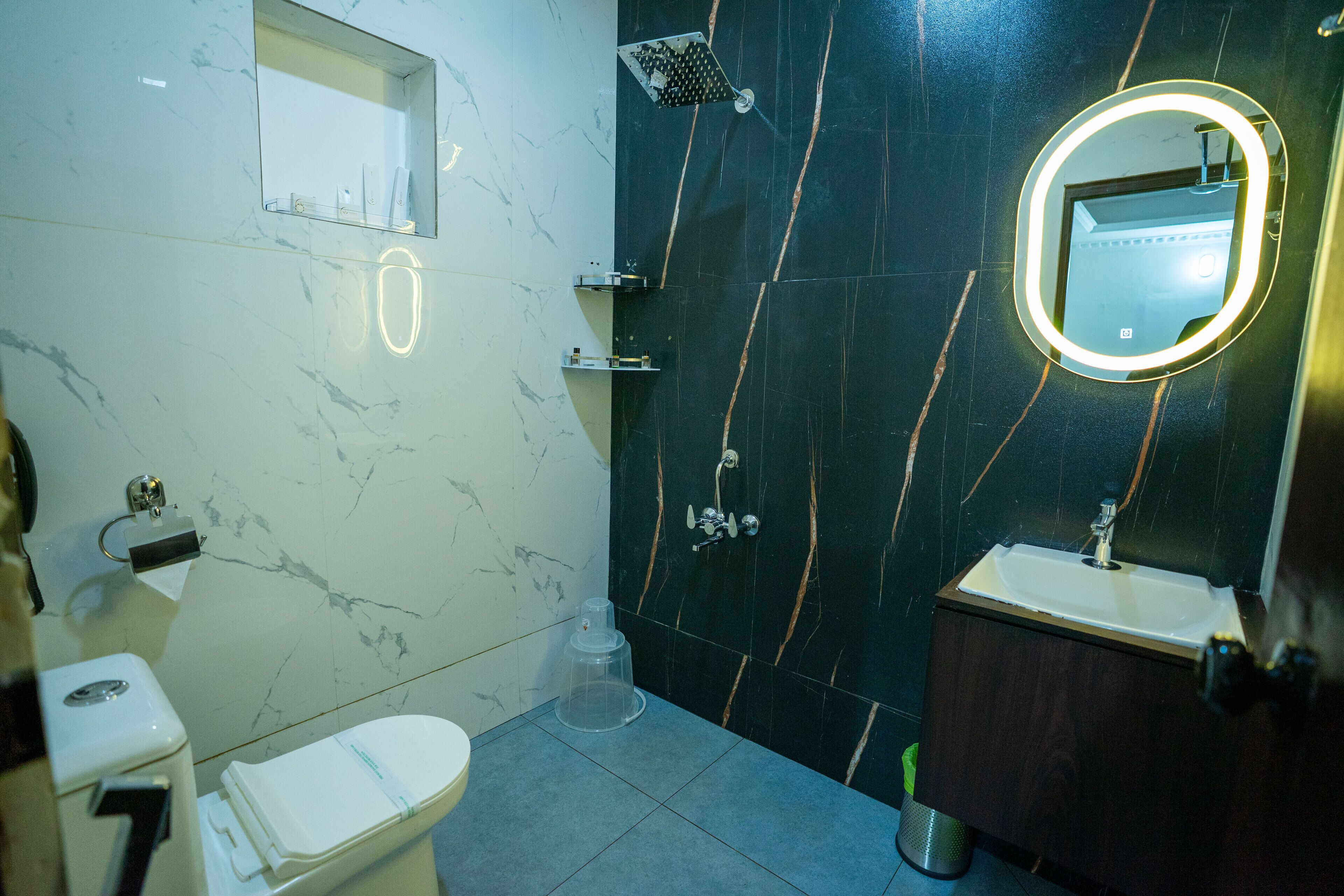 Une salle de bain avec des toilettes, un lavabo et une douche.
