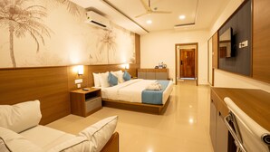 Una camera d'albergo moderna con un letto grande, comodini, televisione e ventilatore a soffitto.
