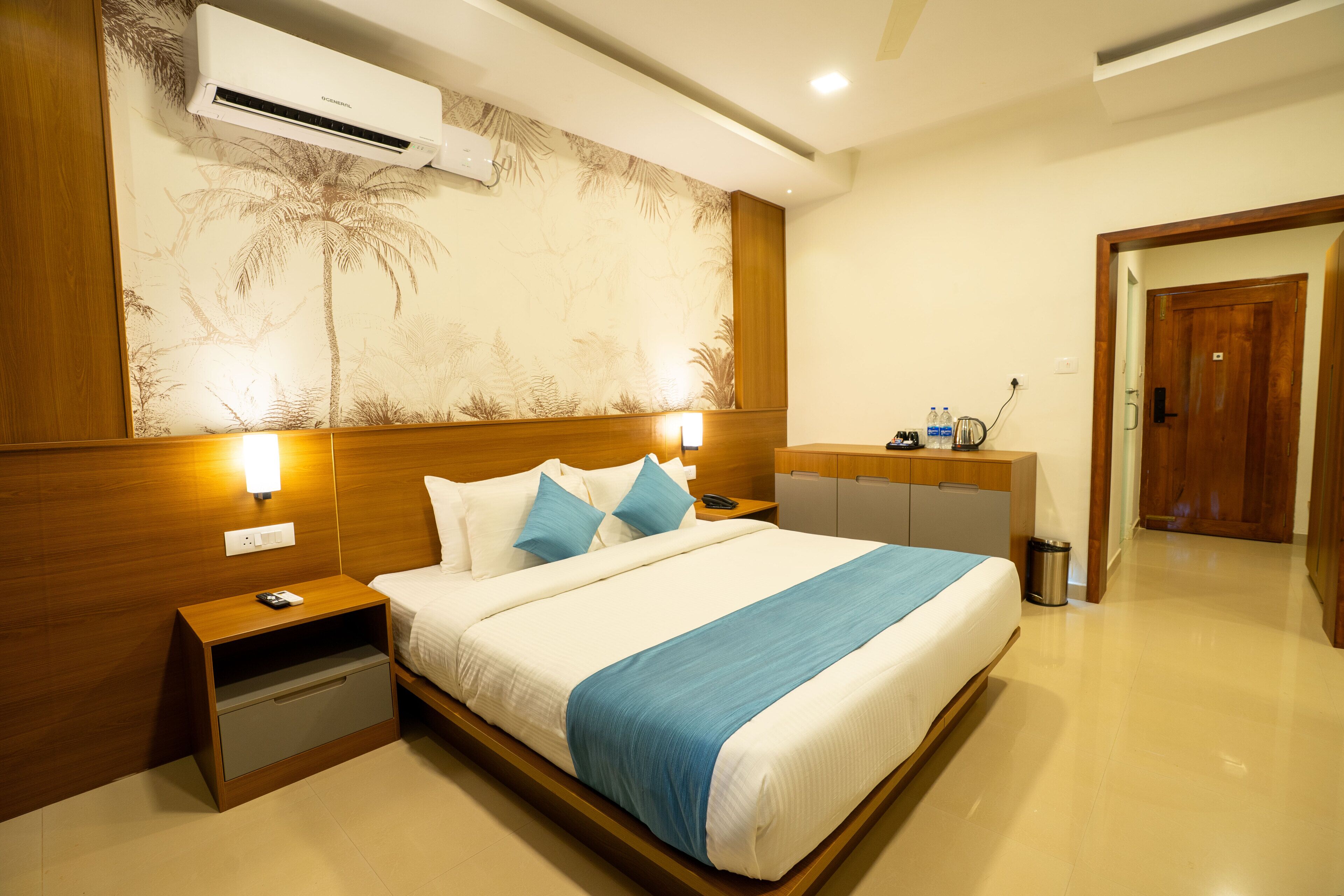 A hotel room with a bed, nightstands, a desk, and a wardrobe.