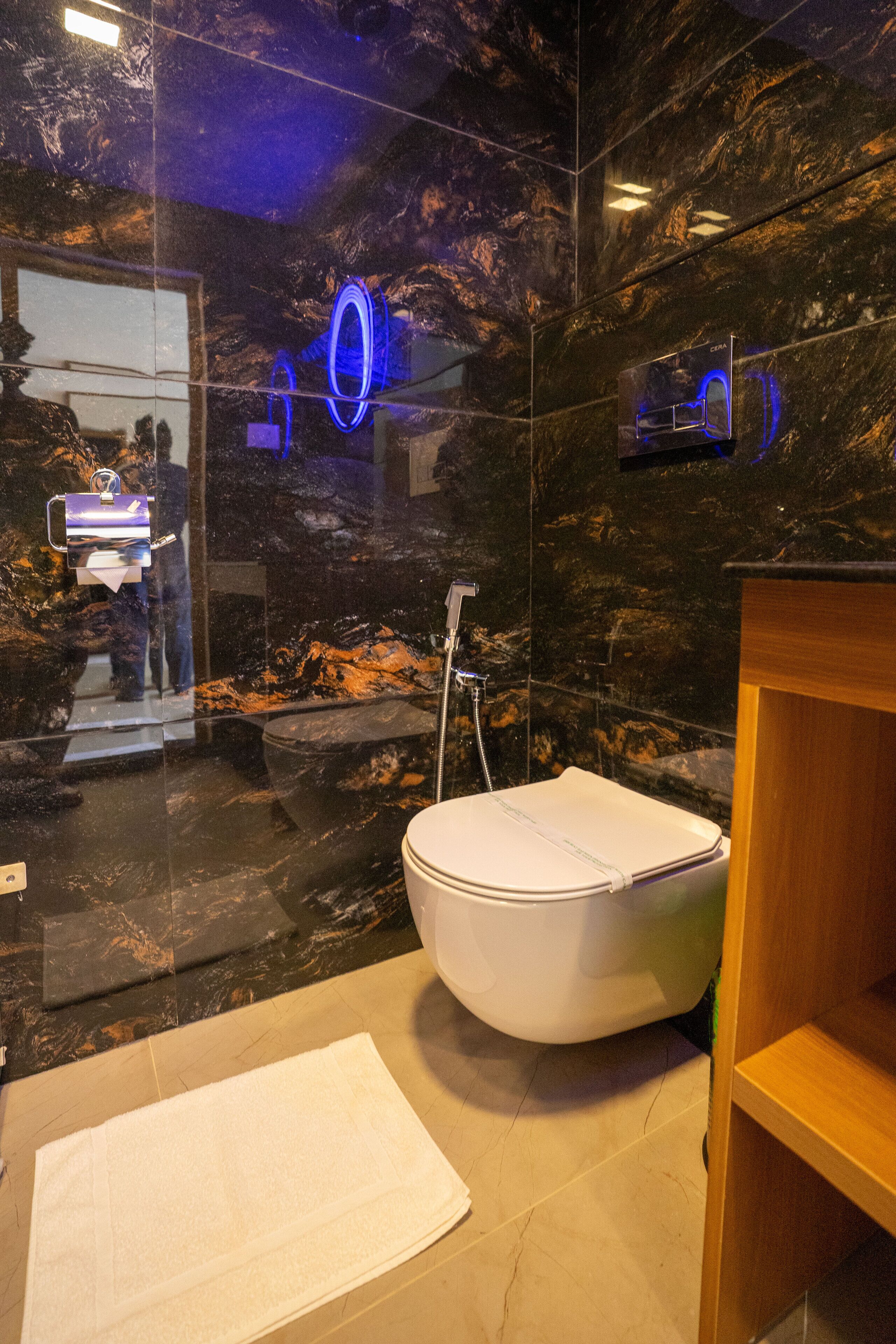 A modern bathroom with a freestanding bathtub, a glass shower enclosure, and a marble wall.