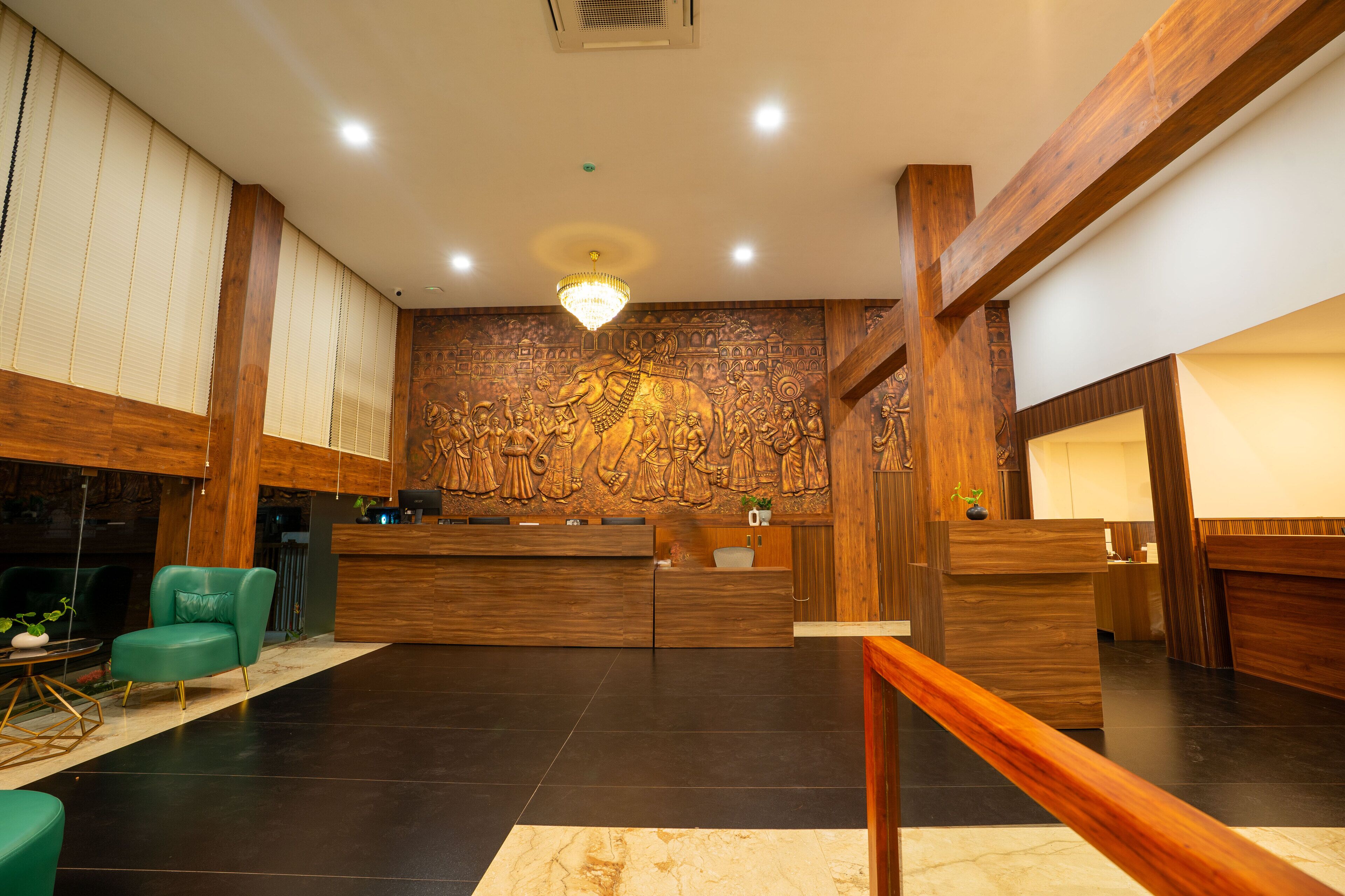A reception area with a wooden reception desk, a green armchair, and a large wall mural.