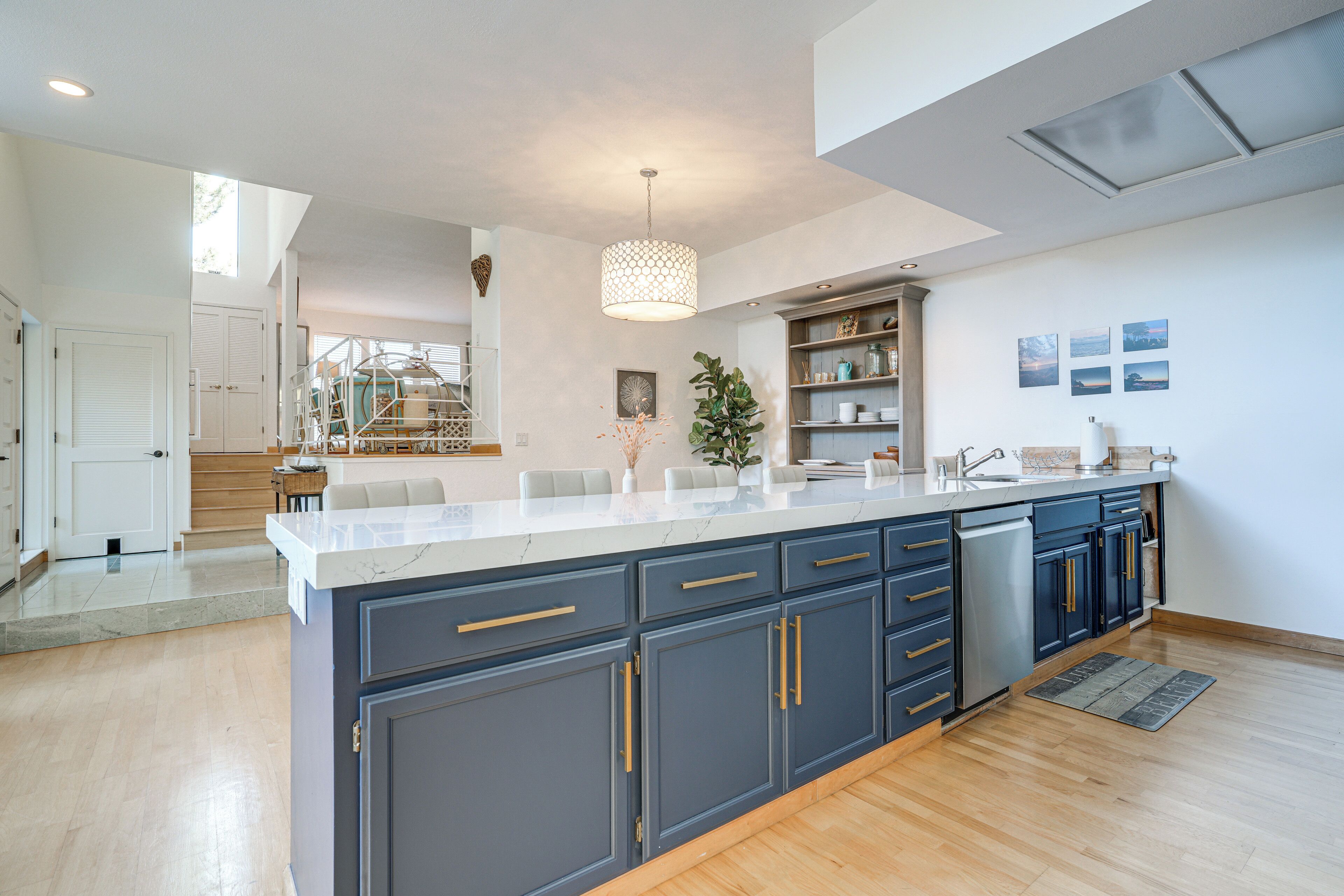 A modern kitchen with a large island, dark blue cabinets, and a white countertop.