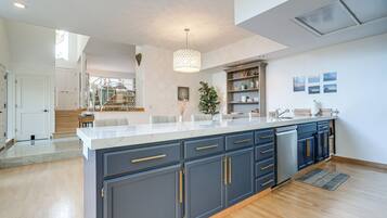 A modern kitchen with a large island, dark blue cabinets, and a white countertop.