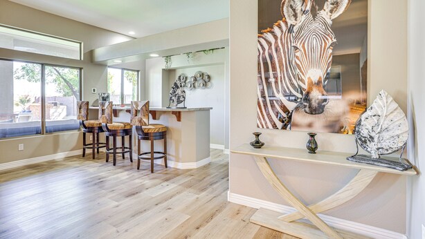 A spacious kitchen with a large island, bar stools, and a zebra artwork on the wall. - Luxe Mtn-view Mansion w/ Hot Tub in Phoenix! (Phoenix)