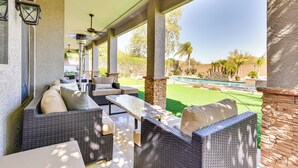 An outdoor patio with wicker furniture, a pool, and a view of the yard. - Luxe Mtn-view Mansion w/ Hot Tub in Phoenix! (Phoenix)