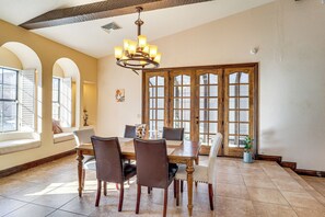 A dining room with a large wooden table, six chairs, and a chandelier. - 7 Mi to Las Vegas Strip: Home w/ Pool (Las Vegas)