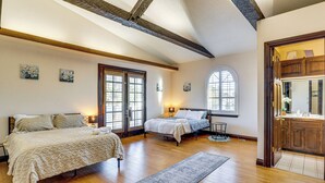 A spacious bedroom with a large bed, a smaller bed, and a walk-in closet.