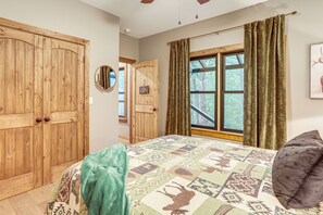 Une chambre avec un grand lit, une armoire en bois, une fenêtre avec des rideaux et une pancarte de bienvenue.