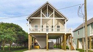 A two-story house with a balcony, a garage, and a covered driveway. - Walk to Crystal Beach: 'the Sandbar Escape' (Port Bolivar)