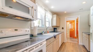 A modern kitchen with a built-in oven, microwave, and a coffee maker on the counter. - Swim, Ski & Sip: Lakefront Retreat in Plymouth (Plymouth)