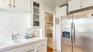 A kitchen with white cabinets, a stainless steel refrigerator, a built-in sink, and a small countertop with a soap dispenser. - 3 Mi to Universal Studios: Chic Home w/ Yard! (Burbank)
