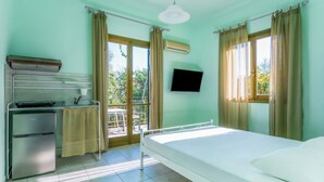 A room with a bed, a small kitchenette, a television, and a window with curtains. - Old Boat (Nikiana)