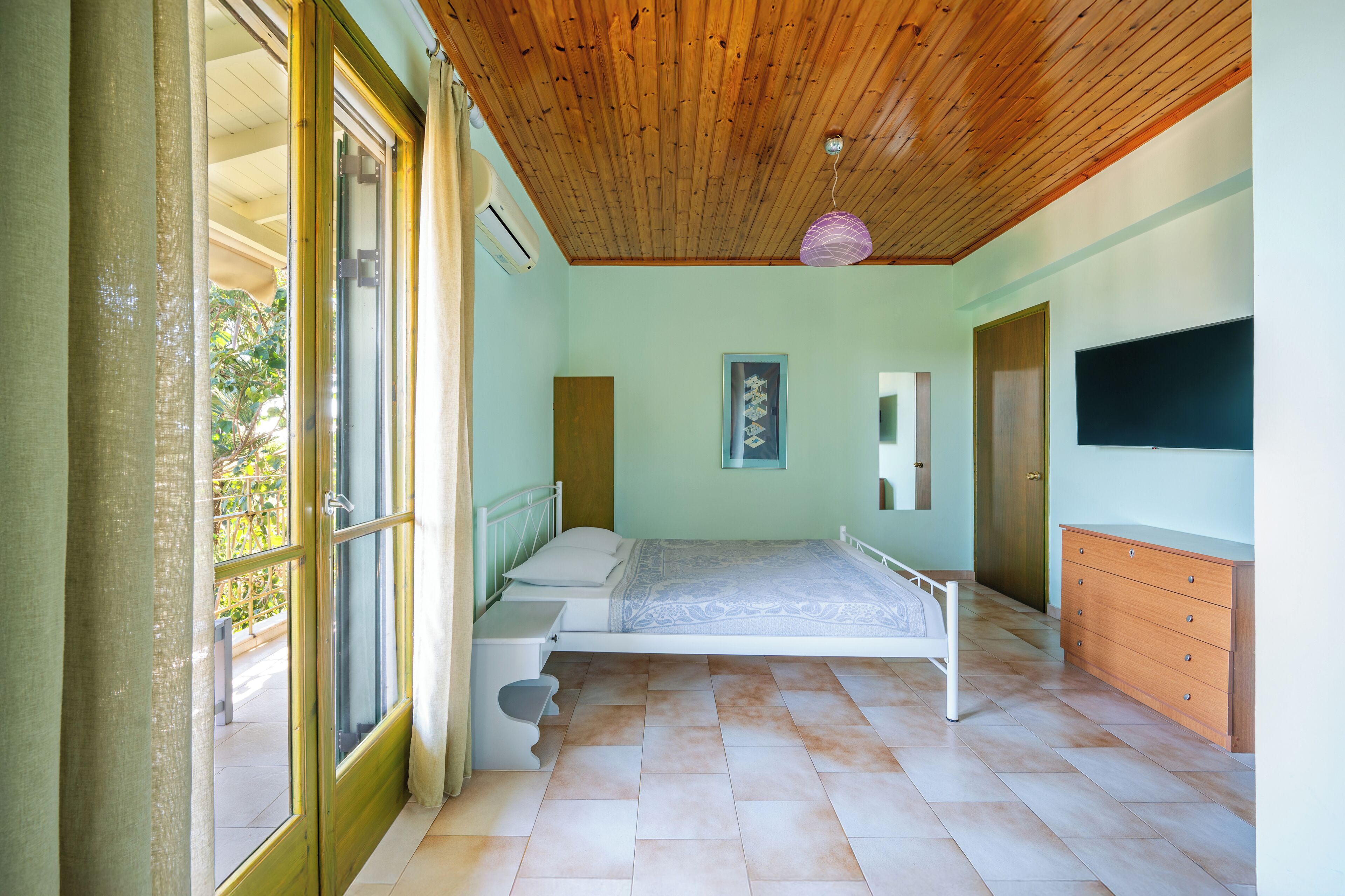 Une chambre à coucher avec un lit, une commode et une fenêtre.