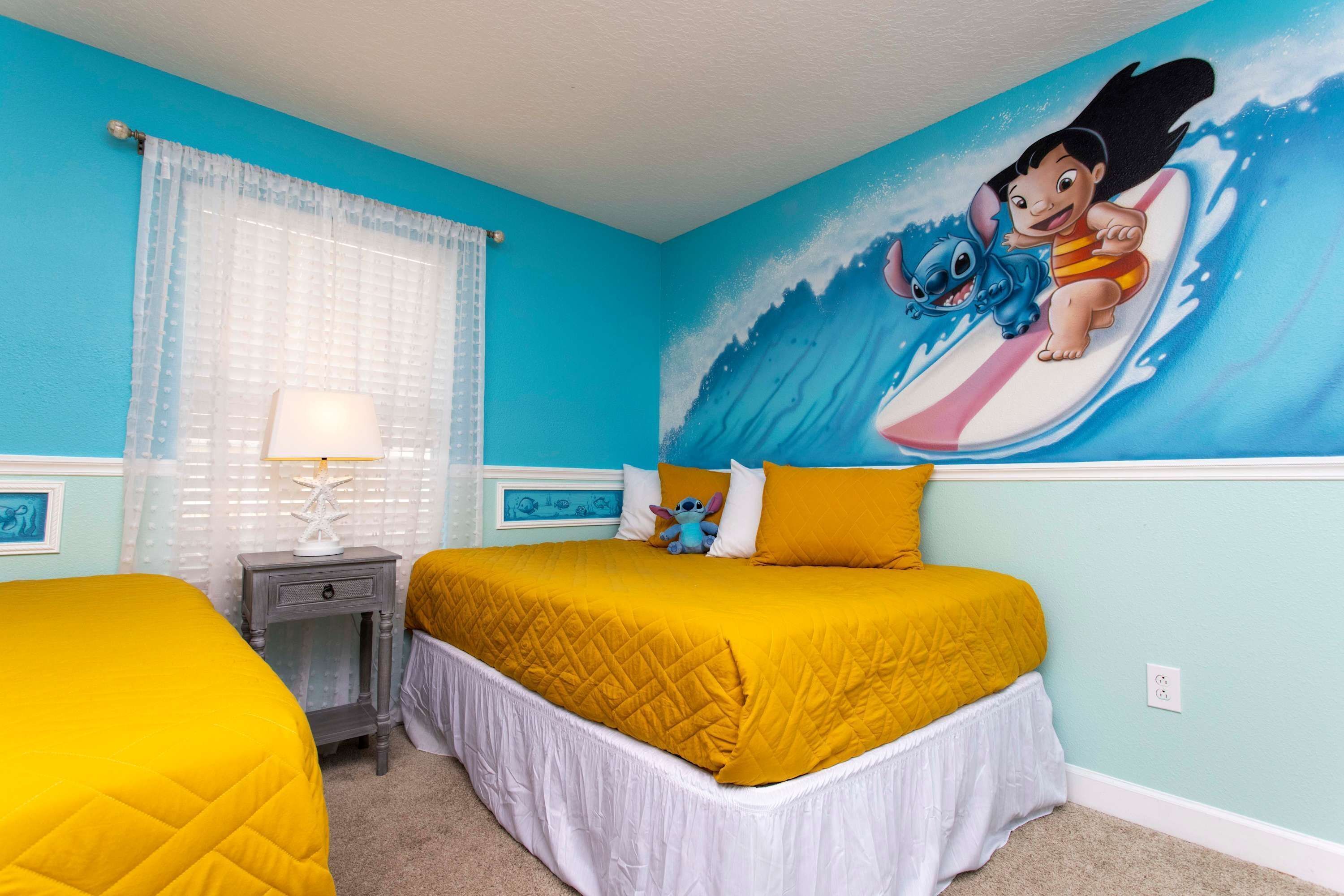 A bedroom with a bed, a nightstand, a lamp, and a wall mural.