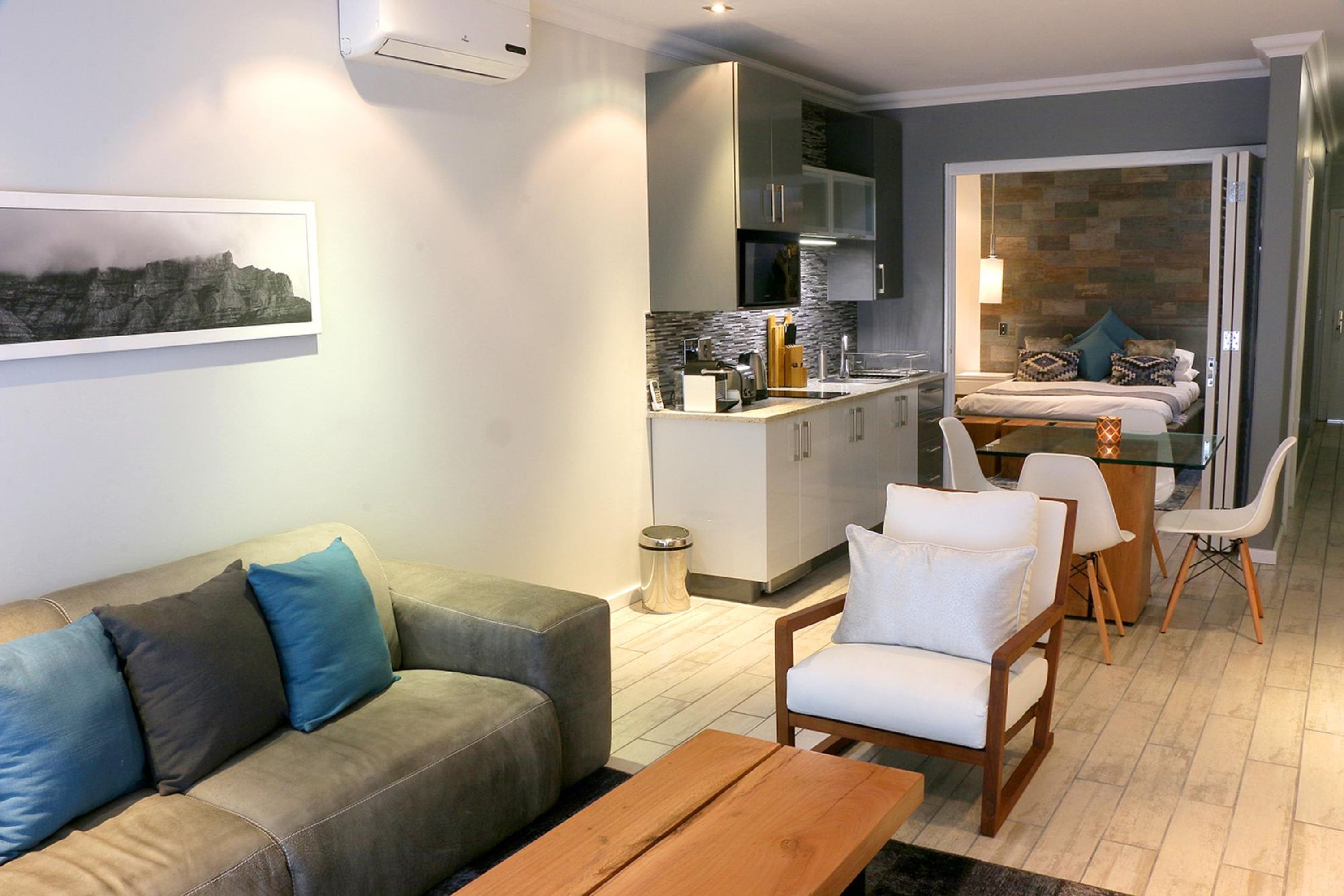 Una sala moderna con sofá, mesa de centro y comedor.