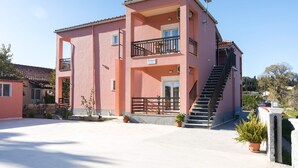 Un bâtiment rose doté d’un balcon, d’un escalier et d’une enseigne sur laquelle on peut lire « Veneti ».