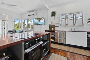 A modern kitchen with a central island, built-in appliances, and large windows offering views of the outdoors.