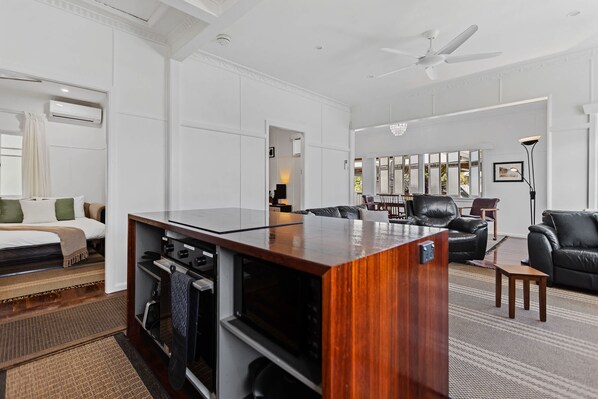 A modern living room with a wooden bar, a sofa, a chair, and a dining area.
