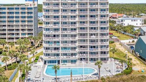 A high-rise hotel with multiple balconies, a swimming pool, and beach access. - Tradewinds 108- 1 Bedroom with Hall Bunks! 2 Full Bathrooms! Updated! (Orange Beach)