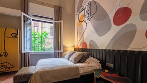 A modern bedroom with a bed, a window with curtains, a wall with abstract art, and a unique bench. - Canvas Boutique Hotel  (Beirut)